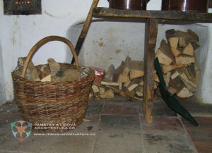 Palivové dřevo v proutěném koši a výklenku pod sporákem, obec Hoslovice, okres Strakonice